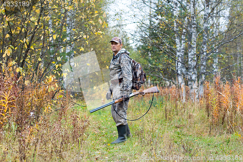 Image of hunter with shotgun on the autumn hunting