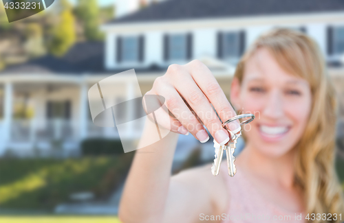 Image of Excited Female Holding House Keys in Front of Nice New Home.