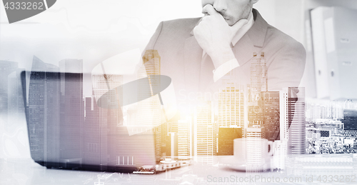 Image of businessman with laptop and coffee at office