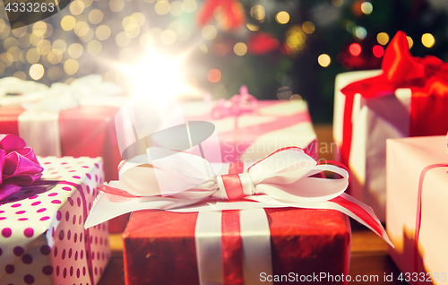 Image of close up of gift boxes over christmas tree lights