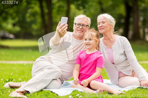 Image of senior grandparents and granddaughter selfie