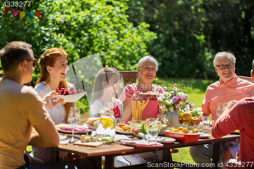 Image of happy family having dinner or summer garden party