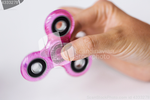 Image of close up of hand playing with fidget spinner