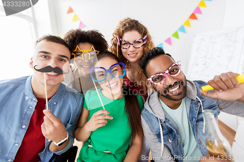 Image of happy friends or team having fun at office party