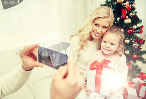 Image of family taking picture with smartphone at christmas