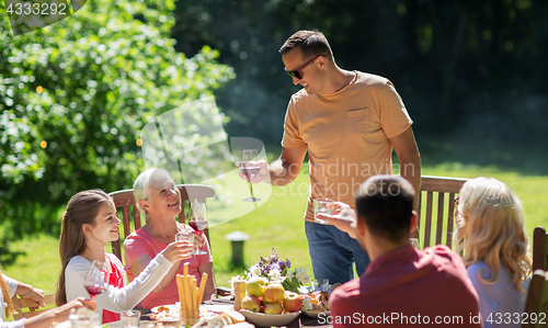 Image of happy family having dinner or summer garden party