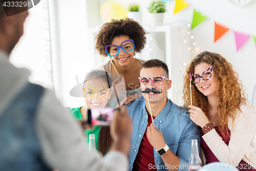 Image of friends or team photographing at office party