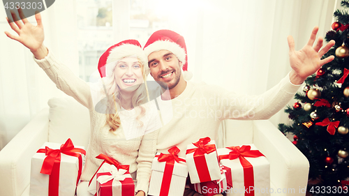 Image of happy couple at home with christmas gift boxes
