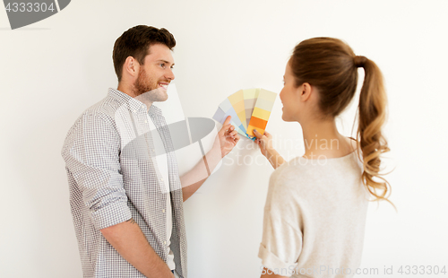 Image of happy couple with color samples at new home