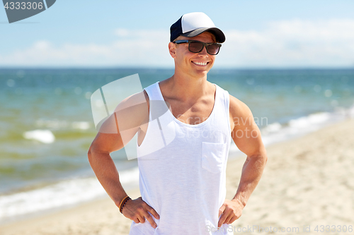 Image of smiling young man in sunglasses on summer beach