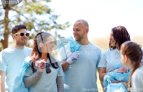 Image of volunteers with garbage bags walking outdoors