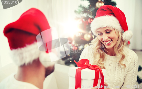 Image of happy couple at home with christmas gift box