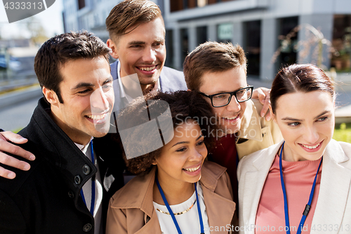 Image of happy people with conference badges taking selfie