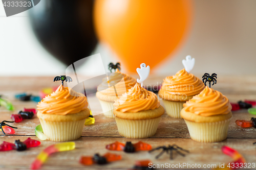 Image of halloween party cupcakes and candies on table