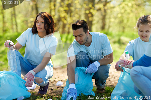 Image of volunteers with garbage bags cleaning park area