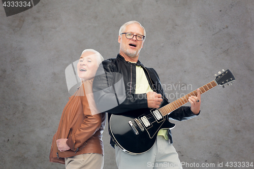 Image of happy senior couple with electric guitar singing