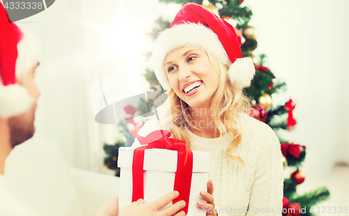 Image of happy couple at home with christmas gift box