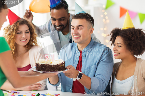 Image of team greeting colleague at office birthday party