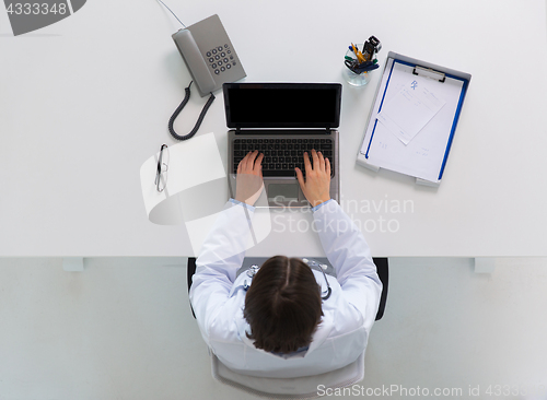 Image of woman doctor typing on laptop at clinic