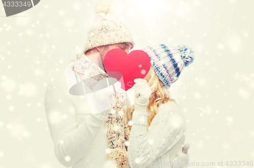 Image of smiling couple in winter clothes with red heart