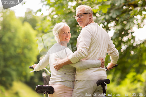 Image of happy senior couple with bicycles at summer park