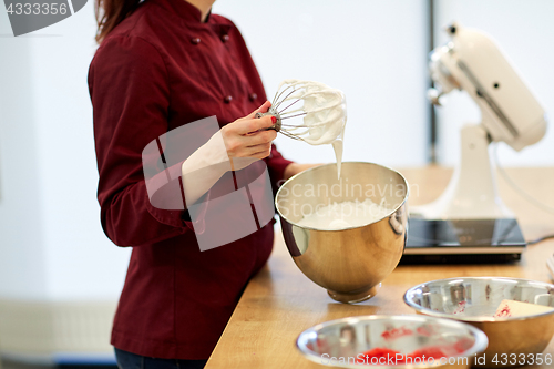 Image of chef with whisk and whipped egg whites at kitchen