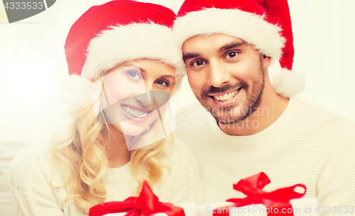 Image of happy couple at home with christmas gift boxes