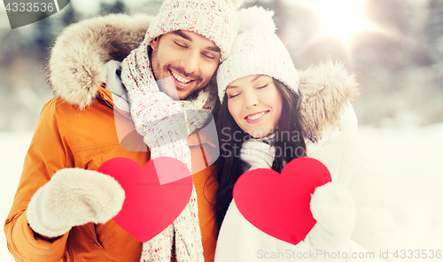 Image of happy couple with red hearts over winter landscape