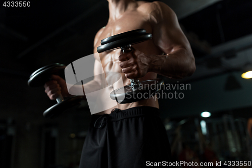 Image of close up of man with dumbbells exercising in gym