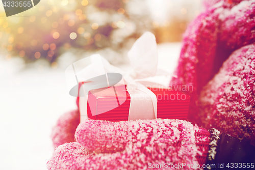 Image of close up of woman holding christmas gift outdoors