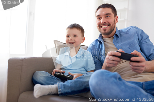 Image of father and son playing video game at home