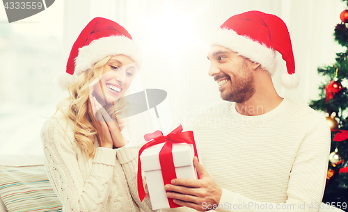 Image of happy couple at home with christmas gift box