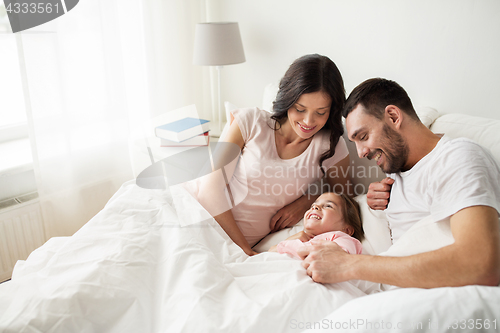 Image of happy family in bed at home