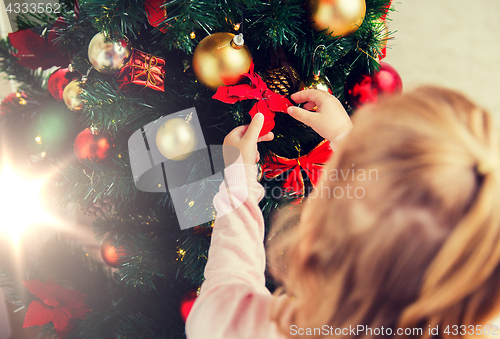 Image of close up of child decorating christmas tree