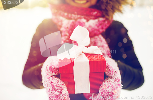 Image of close up of woman with christmas gift outdoors