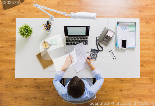 Image of businesswoman with tax report at office