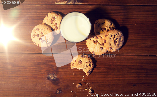 Image of close up of oat cookies and milk on wooden table