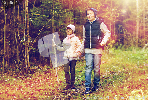 Image of two happy kids walking along forest path