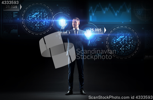 Image of businessman working with charts on virtual screen