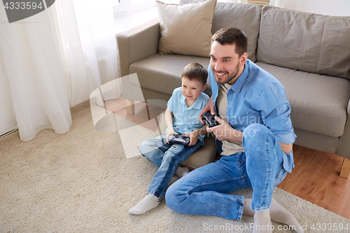 Image of father and son playing video game at home