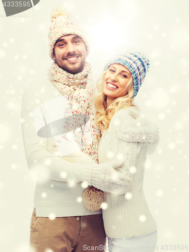 Image of smiling couple in winter clothes hugging