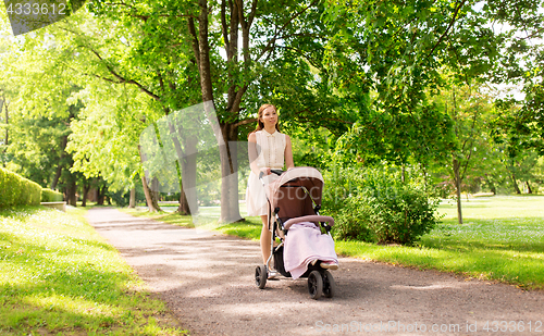 Image of happy mother with child in stroller at summer park