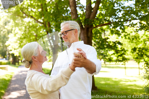 Image of happy senior couple dancing at summer city park