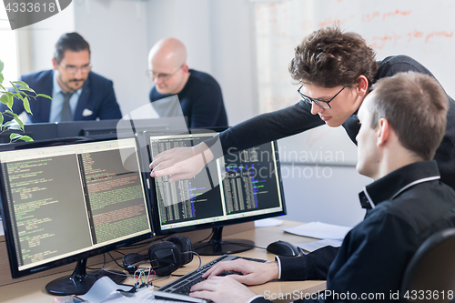Image of Startup business problem solving. Software developers working on desktop computer.