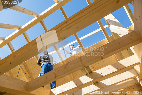 Image of Builders at work with wooden roof construction.