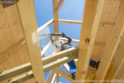 Image of Builder at work with wooden roof construction.