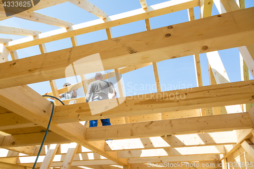 Image of Builders at work with wooden roof construction.