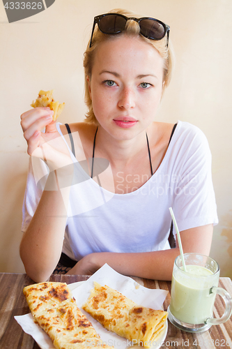 Image of Woman eating traditional moroccan breakfast in coffee shop.