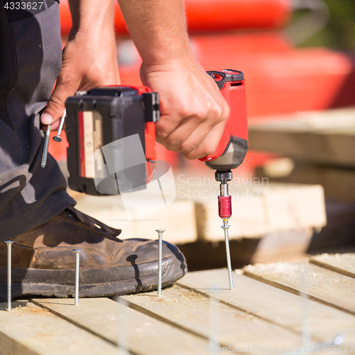 Image of Carpenter working with an electric screwdriver.