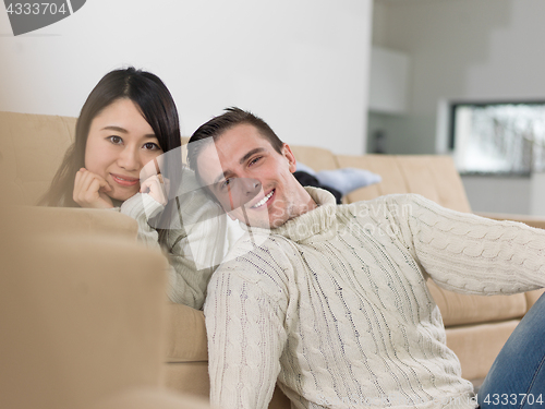 Image of happy multiethnic couple relaxing at home